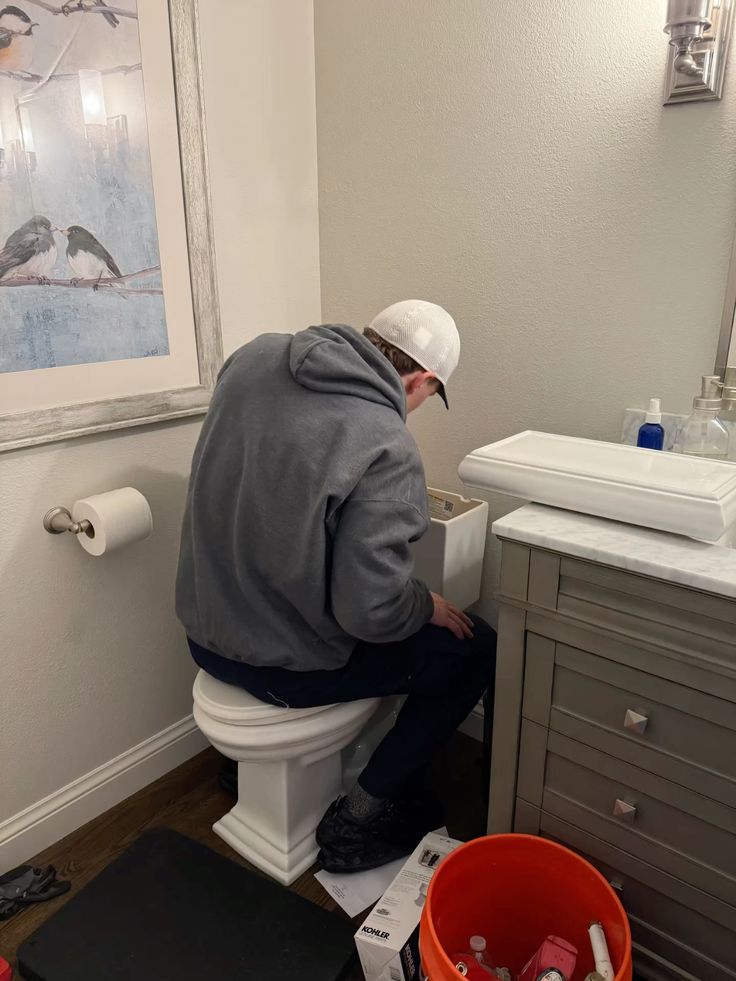 Plumber servicing toilet cistern